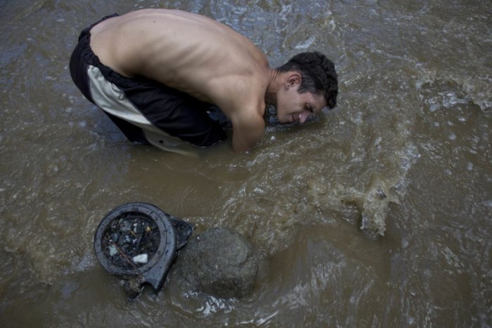 Нищие венесуэльцы ищут сокровища в зловонной грязной реке