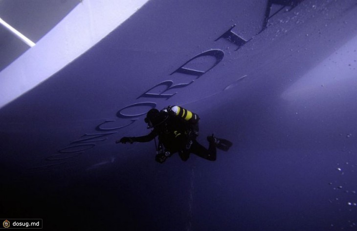 Позже лайнер почти полностью погрузился в Средиземное море. Аквалангист осматривает корпус затонувшего круизного судна Costa Concordia спустя шесть дней, 19 января 2012.