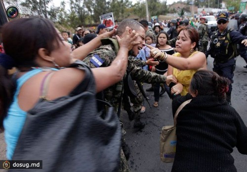Женщины дерутся с солдатом во время акции протеста возле здания Национального Конгресса в Тегусигальпе, Гондурас.