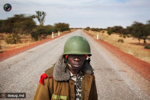 Малийский солдат стоит на дежурстве на дороге недалеко от Севарэ, Мали.