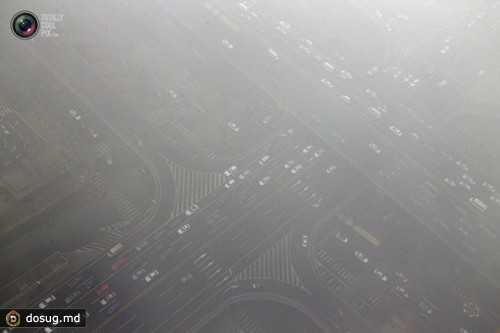 Автомобили едут в тумане по мосту Guomao в деловом районе Пекина, Китай. 
