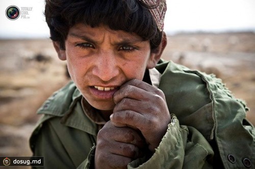 Афганский мальчик стоит возле аванпоста AJK в районе Майванд в провинции Кандагар.