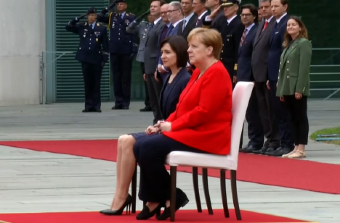 Ангела Меркель и премьер-министр Молдовы Майя Санду сидя прослушали национальные гимны перед переговорами в Берлине