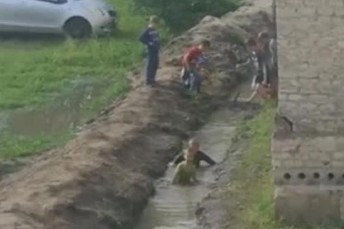 Российские дети устроили купания в грязной канаве