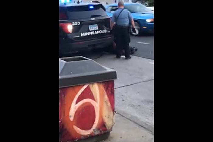 Полицейский прижал коленом шею умоляющего о помощи темнокожего мужчины