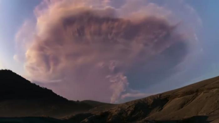 Молния сверкает сквозь облако пепла, выброшенного во время извержения вулкана